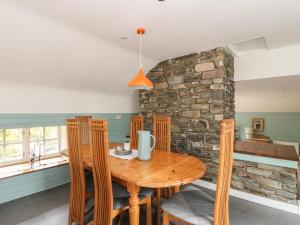 a dining room with a wooden table and chairs at Culearn Mill in Lochearnhead