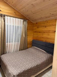 a bedroom with a bed in a wooden cabin at Issyk-kul home in Korumdy