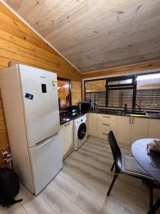 a kitchen with a white refrigerator and a table at Issyk-kul home in Korumdy
