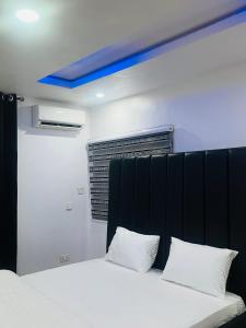 a bed with a black headboard and two white pillows at Executive villa in Aja