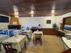 a restaurant with tables and chairs in a room at Pousada D' Paula in Campos do Jordão