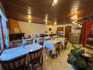 a restaurant with tables and chairs in a room at Pousada D' Paula in Campos do Jordão