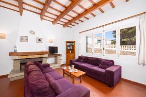 a living room with purple couches and a fireplace at Villa Trepuco Uno in Punta Prima