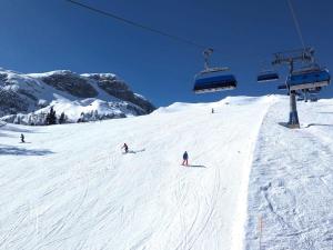 a group of people skiing down a snow covered ski slope at Siwitz 55 in Lake Pressegg