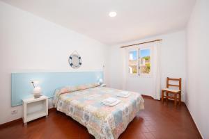 a bedroom with a bed and a table and a window at Villa Trepuco Uno in Punta Prima +15 photos