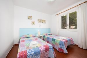 two twin beds in a room with a window at Villa Trepuco Dos in Punta Prima +15 photos