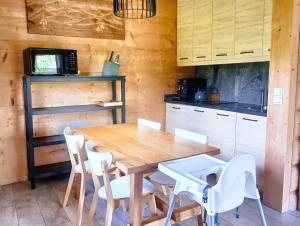 eine Küche mit einem Holztisch und weißen Stühlen in der Unterkunft DOMEK POLANKA z sauną i widokiem na Tatry in Witów