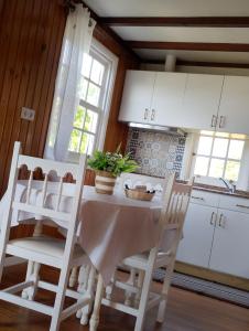 a kitchen with a white table and chairs at La cabaña in Cedeira