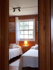 a bedroom with two beds and a window at La cabaña in Cedeira