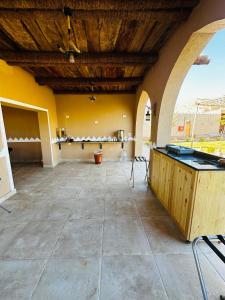 a large room with a stone floor and a wooden ceiling at Happy Oasis Hotel in Siwa
