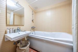 a bathroom with a sink and a bath tub at Bright Studio in Rotermann Quarter - Noor Apartment in Tallinn