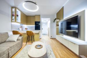 a living room with a couch and a large television at Bright Studio in Rotermann Quarter - Noor Apartment in Tallinn