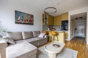 a living room with a couch and a table at Bright Studio in Rotermann Quarter - Noor Apartment in Tallinn