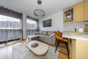 a living room with a couch and a table at Bright Studio in Rotermann Quarter - Noor Apartment in Tallinn +7 photos