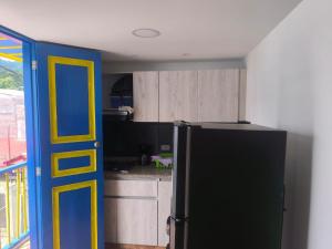 a kitchen with a black refrigerator and a yellow door at apartamento vacacional in Salento +3 photos