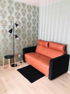 an orange couch in a room with a lamp at Apartment VV in Volodymyr-Volynskyi