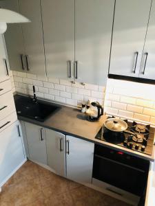 a kitchen with white cabinets and a stove top oven at Apartment VV in Volodymyr-Volynskyi