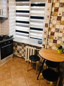 a kitchen with a wooden table and chairs and a table and window at Apartment VV in Volodymyr-Volynskyi