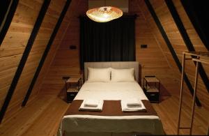 a bedroom with a large bed with a chandelier at Eylül Bungalow Kaş in Kaş