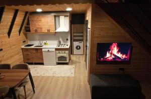 a kitchen with a living room with a fire on the wall at Eylül Bungalow Kaş in Kaş