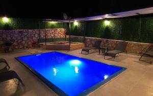 a large swimming pool in a backyard at night at Eylül Bungalow Kaş in Kaş +8 photos