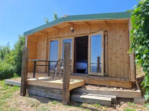 a wooden cabin with a deck and a table at Cedre bleu in Saint-Racho +4 photos