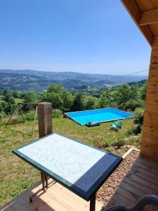 a ping pong table on a deck with a pool at Cedre bleu in Saint-Racho