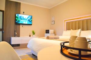 a hotel room with two beds and a flat screen tv at ECO-WILD Luxury Suites in Windhoek