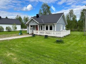 a small white house with a large yard at Kukkolaforsen 160 in Haparanda