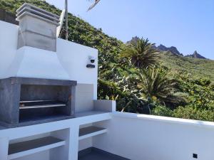 a white house with a fireplace and a mountain at Nido Anaga in Santa Cruz de Tenerife