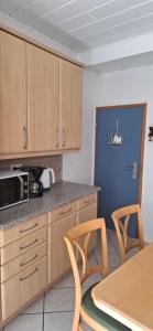 a kitchen with wooden cabinets and a table and chairs at Ferienwohnung Thomas in Adenbach