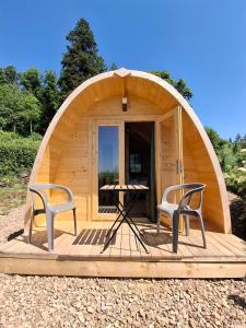 two chairs and a table in a circular building at Houx POD in Saint-Racho