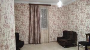 a living room with a chair and a window at Nino in Kaspi