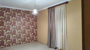 a room with a wall with a curtain and a window at Nino in Kaspi