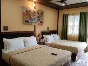 a hotel room with two beds in a room at Trinetra Himalayan Stay in Phata