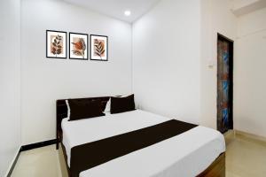 a white bedroom with a black and white bed at Super Hotel O P3 Thumkunta in Hyderabad
