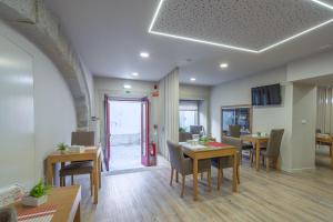 a dining room with tables and chairs in a room at Rua Grande Hotel in Viana do Castelo