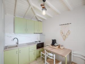 a kitchen with green cabinets and a wooden table at Pension Votsi in Votsi