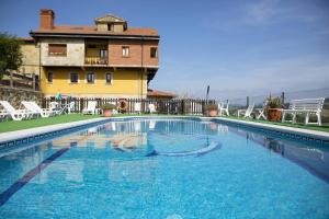 a large swimming pool in front of a building at Apartamentos La Gloria in Santillana del Mar