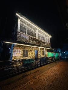 a building with lights on the side of it at night at ROGHAY COTTAGE in Matheran