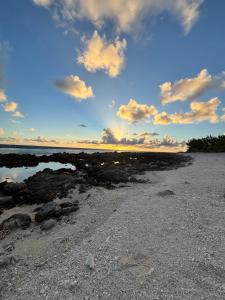 ein Strand mit Felsen und einem bewölkten Himmel in der Unterkunft Faatiarau in Fakarava