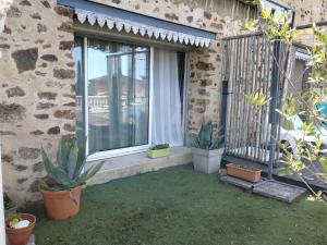 a patio with potted plants and a window at Chambre en Havre de paix in Panazol