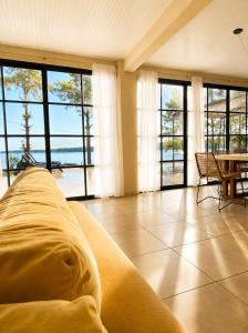 a living room with a couch and a table and windows at Casa Ypá in Puerto Libertad