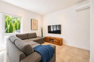 a living room with a couch and a flat screen tv at Amazing 2BR condo with private terrace presented by TripMontreal II in Montreal