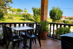 a table and chairs sitting on a balcony at Apartamentos La Gloria in Santillana del Mar