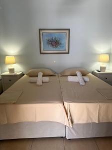a large bed in a bedroom with two lamps at Villa Maria-Stunning Villa in Porto Hydra in Thermisía