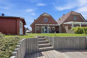 a house with a wooden fence in front of it at Friesenperle in Greetsiel