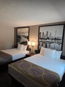 two beds in a hotel room with a view of the water at Super 8 by Wyndham Guelph in Guelph
