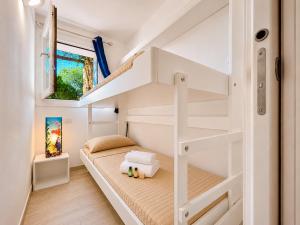 a small bedroom with a bunk bed and stairs at Sunset Three Shared Pool 100m from the Beach in Baja Sardinia +13 photos
