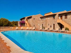 a villa with a swimming pool in front of a building at Sunset Three Shared Pool 100m from the Beach in Baja Sardinia